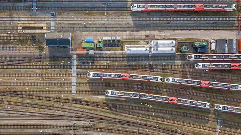 Züge fahren auf Gleisen, fotografiert aus der Vogelperspektive.