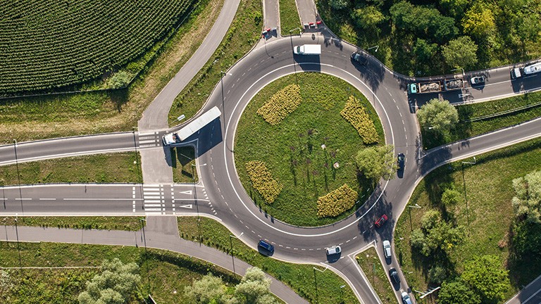 Ein Kreisel in der Nähe einer Autobahn aus der Vogelperspektive.